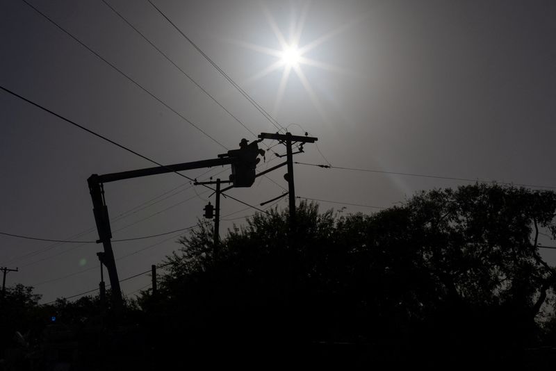 &copy; Reuters. FILE PHOTO: A man with American Electric Power (AEP) repairs an electricity cable during a heatwave in Eagle Pass, Texas, U.S. July 28, 2023.  REUTERS/Adrees Latif/File Photo