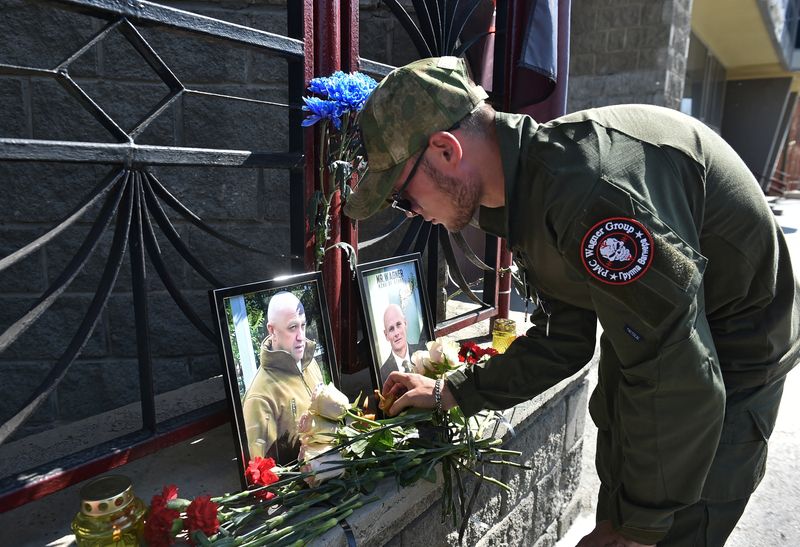 &copy; Reuters. A fighter of Wagner private mercenary group lights a candle at a makeshift memorial with portraits of Russian mercenary chief Yevgeny Prigozhin and Wagner group commander Dmitry Utkin outside the local office of the Wagner private mercenary group in Novos