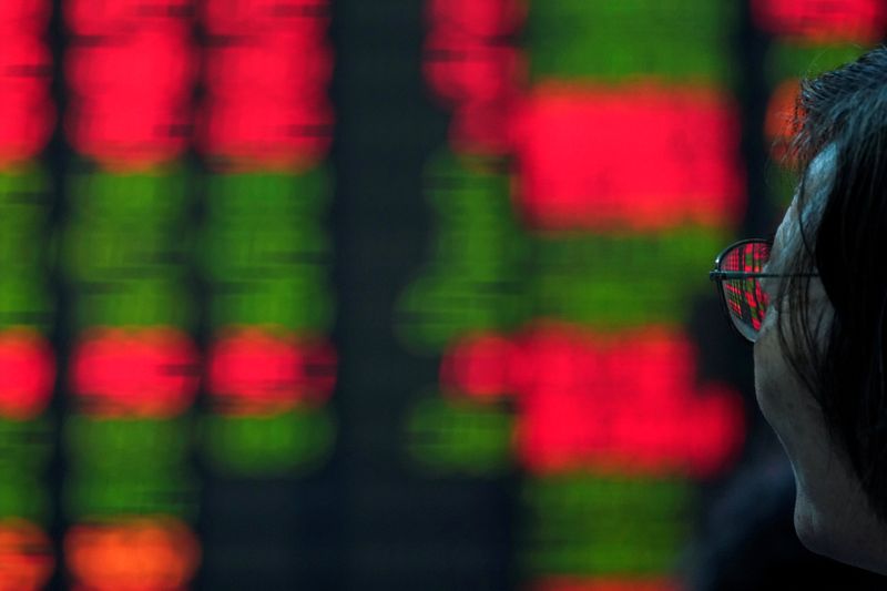 &copy; Reuters. FILE PHOTO: An investor looks at an electronic board showing stock information at a brokerage house in Shanghai, China July 6, 2018. REUTERS/Aly Song