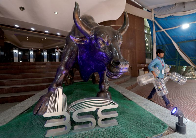 &copy; Reuters. FILE PHOTO: A man carries empty water bottles past a bronze replica of the Charging Bull of Wall Street, inside the premises of the Bombay Stock Exchange (BSE) in Mumbai, February 1, 2023. REUTERS/Niharika Kulkarni/File Photo