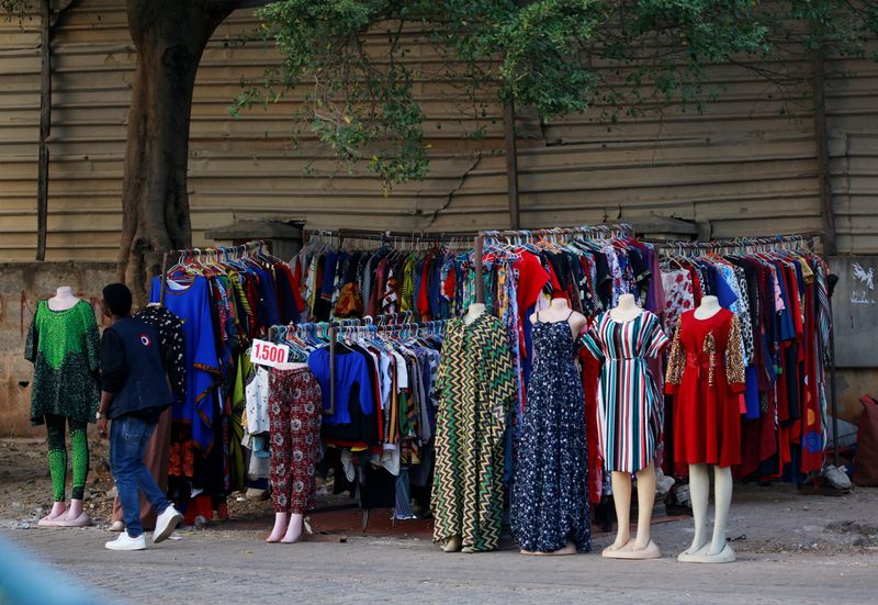 &copy; Reuters. FILE PHOTO: A man walks past a display of woman's clothes for sale under a tree in Abuja, Nigeria November 21, 2020. REUTERS/Afolabi Sotunde/File Photo