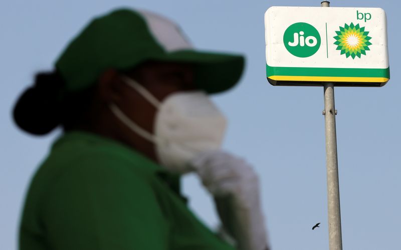 &copy; Reuters. An attendant stands next to a logo of Jio-bp, an Indian fuel and mobility joint venture between Reliance Industries (RIL) and British Petroleum (bp), in Navi Mumbai, India, October 26, 2021 REUTERS/Francis Mascarenhas/File photo