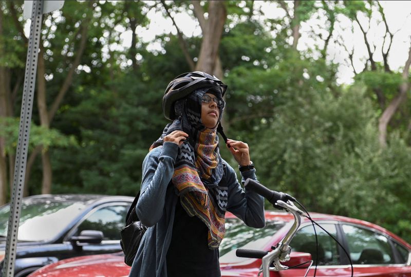 &copy; Reuters. Shaira Tasnia, 16, puts her helmet on while on a group cycling trip with community program Hijabs and Helmets, in Scarborough, Ontario, Canada, August 17, 2023.  REUTERS/Laura Proctor