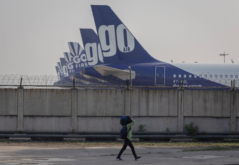 &copy; Reuters. FILE PHOTO: A man carries his bag as he walks past the Go First airline, formerly known as GoAir, passenger aircrafts parked on the tarmac at the airport in New Delhi, India, May 11, 2023. REUTERS/Adnan Abidi/File Photo