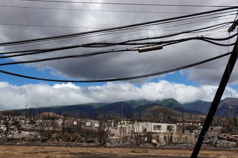 © Reuters. A utility pole stands leaning next to the fire ravaged town of Lahaina on the island of Maui in Hawaii, U.S., August 15, 2023. REUTERS/Mike Blake