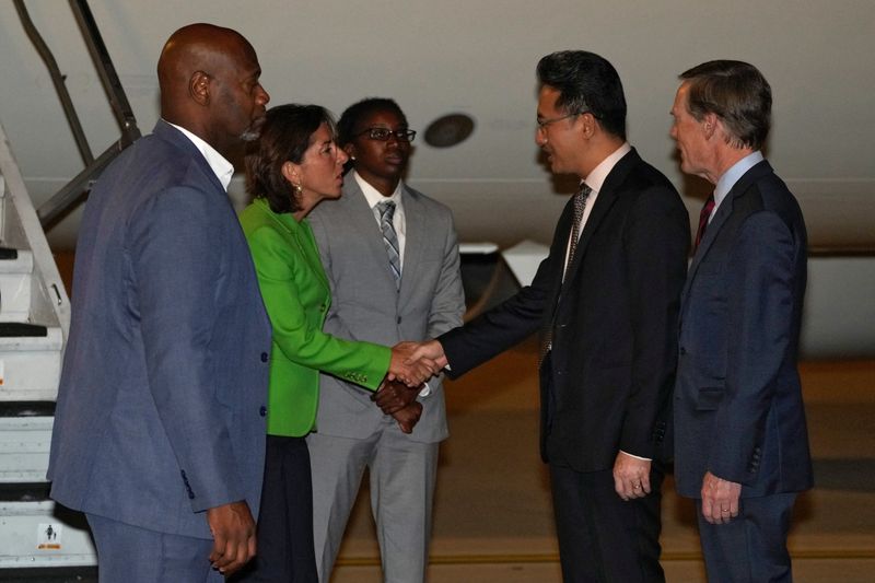 © Reuters. La Secretaria de Comercio de EE.UU., Gina Raimondo, estrecha la mano de Lin Feng, Director General del Ministerio de Comercio de China, mientras el Embajador de EE.UU. en China, Nick Burns, la observa a su llegada al Aeropuerto Internacional de Pekín Capital en Pekín, domingo 27 de agosto de 2023. Andy Wong/Pool vía REUTERS 