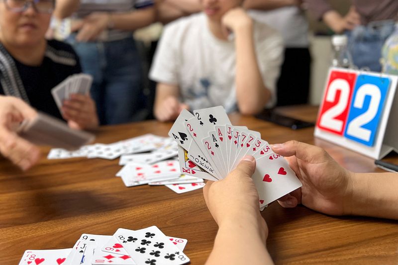 © Reuters. Finance professionals learn how to play guandan, a poker-like card game, during a training session in Beijing, China August 6, 2023. REUTERS/Yew Lun Tian/File photo