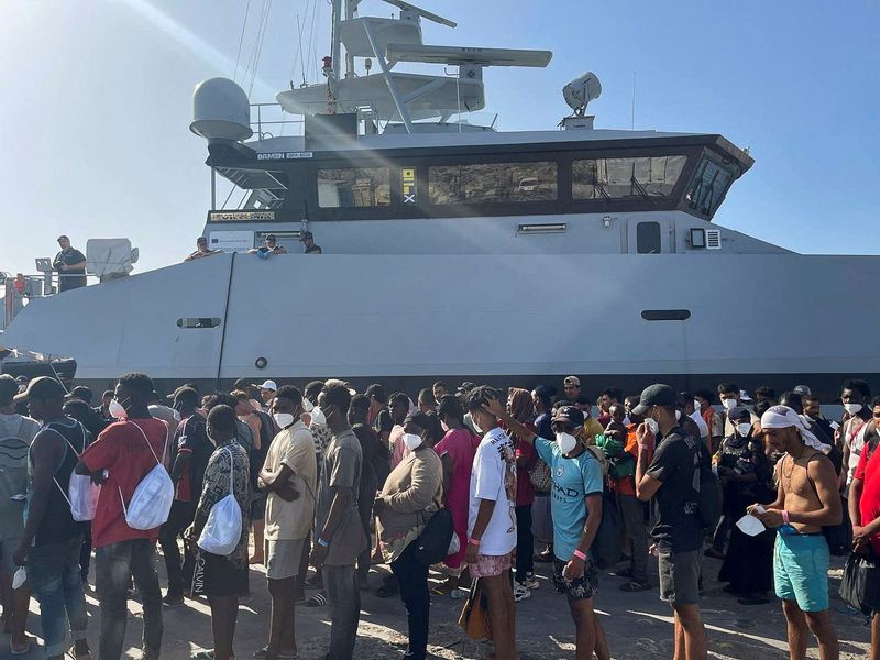 &copy; Reuters. Des migrants attendent dans le port de Lampedusa, en Italie. /Photo prise le 27 août 2023/REUTERS/Tony Colapinto