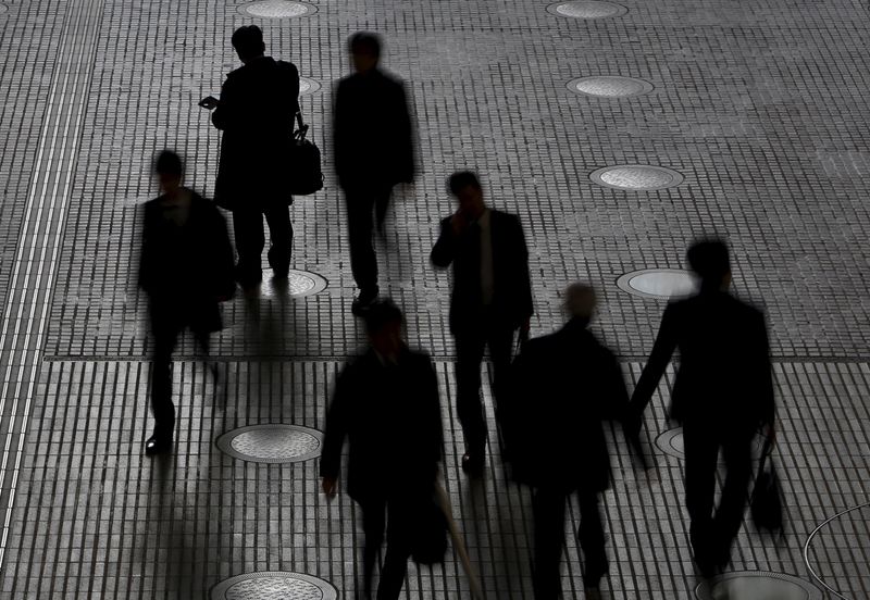 © Reuters. People walk at an office building at a business district in Tokyo, Japan, February 29, 2016.  REUTERS/Yuya Shino 