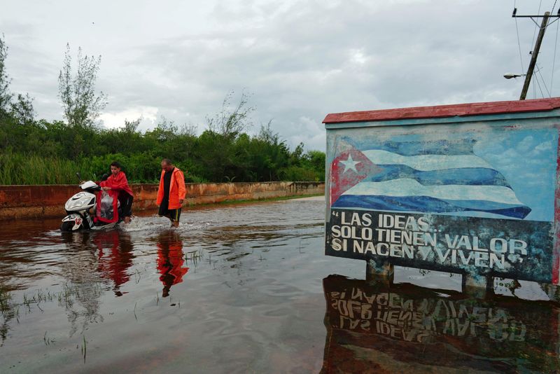 &copy; Reuters. People walk on a flooded street as Storm Idalia makes landfall in Cuba, Guanimar, Cuba, August 28, 2023.  REUTERS/Alexandre Meneghini