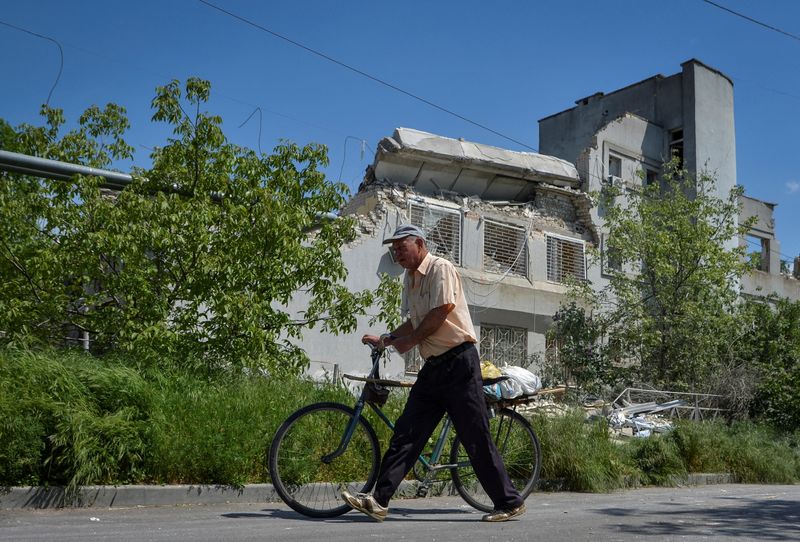 &copy; Reuters. Homem passa em frente a prédio de escola danificado por um ataque de um drone russo em Kherson, na Ucrânia
15/05/2023 REUTERS/Ivan Antypenko