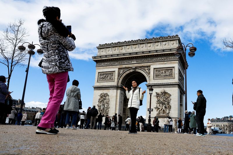 &copy; Reuters. Des touristes chinois prennent des photos sur l'avenue des Champs Elysées près de l'Arc de Triomphe à Paris, France. /Photo prise le 14 mars 2023/REUTERS/Gonzalo Fuentes