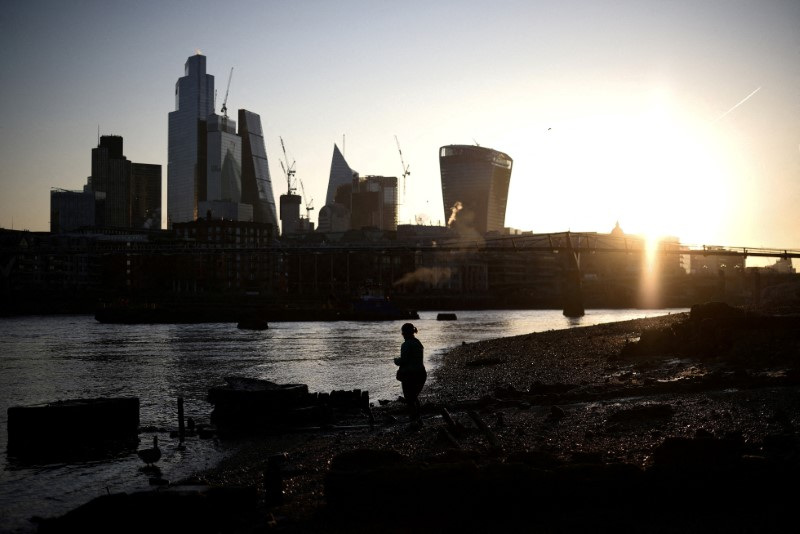 &copy; Reuters. FILE PHOTO: A person stands on the bank of the River Thames during sunrise, with the City of London financial district in the background, in London, Britain, April 4, 2023. REUTERS/Henry Nicholls