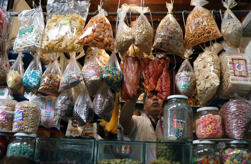 &copy; Reuters. FILE PHOTO: A man sells groceries at a stand at Surco market in Lima, Peru August 31, 2018.  REUTERS/Mariana Bazo/File Photo