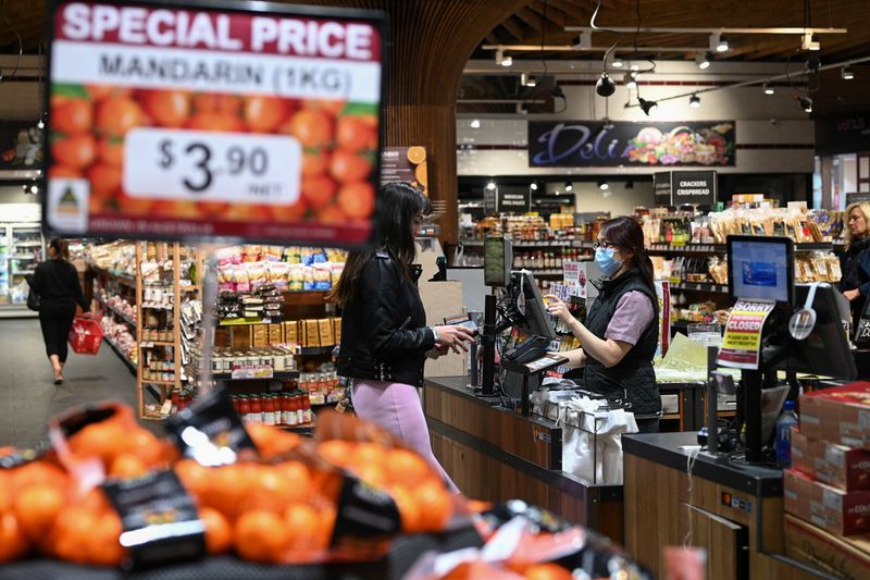 &copy; Reuters. FILE PHOTO: An employee wears a protective face mask while ringing up a customer at a specialty grocery store following the easing of restrictions implemented to curb the spread of the coronavirus disease (COVID-19) in Sydney, Australia, June 17, 2020.  R