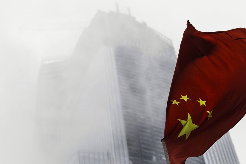 © Reuters. FILE PHOTO: A Chinese national flag flutters in front of a construction site in Guangzhou, Guangdong province, November 7, 2014. REUTERS/Alex Lee/File Photo