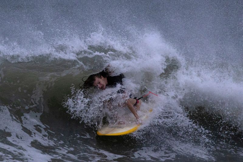 &copy; Reuters. Un surfista surca las olas antes del huracán Idalia en Clearwater Beach, Florida, EEUU. 29 de agosto de 2023. REUTERS/Adrees Latif