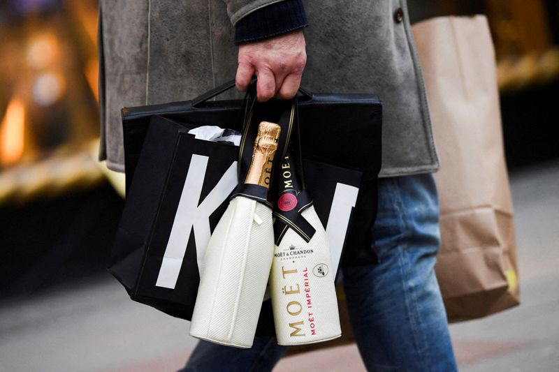 &copy; Reuters. FILE PHOTO: A man carries a shopping bag and bottles of sparkling wine of Moet & Chandon near the department store KaDeWe, amid the coronavirus disease (COVID-19) pandemic, in Berlin, Germany December 23, 2021. REUTERS/Annegret Hilse/File Photo