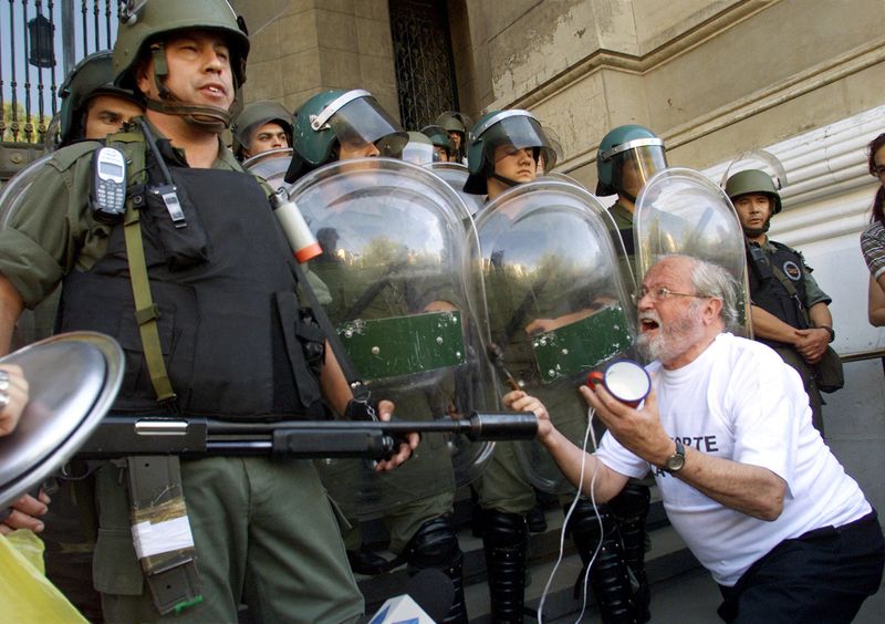 &copy; Reuters. FILE PHOTO: A man pleads with riot police during protests against the Supreme Court and its backing of banking curbs, in Buenos Aires, Argentina January 10, 2002. REUTERS/Rickey Rogers/File Photo
