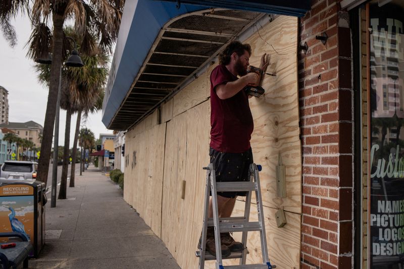 &copy; Reuters. Steve Pizzano helps board up a friend's souvenir shop ahead of the arrival of Hurricane Idalia in Clearwater Beach, Florida, U.S., August 29, 2023.  REUTERS/Adrees Latif