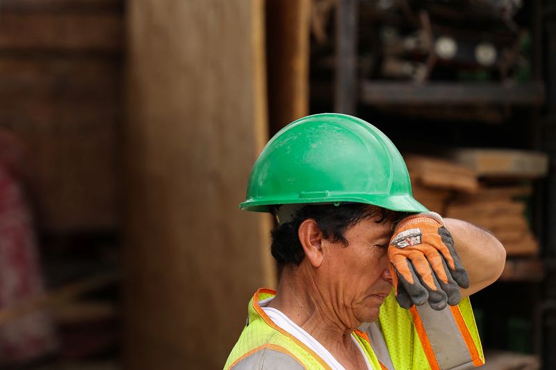 © Reuters. FILE PHOTO: A construction worker is seen wiping sweat from his forehead while working in Washington, U.S., August 15, 2023. REUTERS/Kevin Wurm