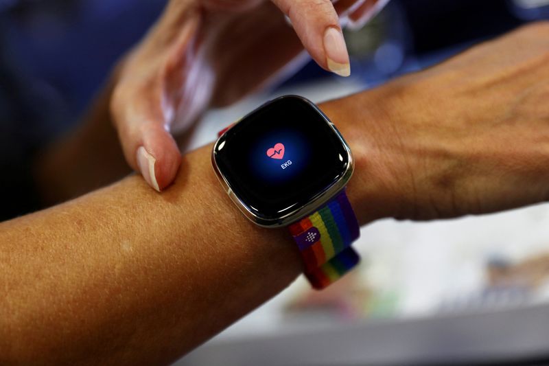 &copy; Reuters. FILE PHOTO: An employee uses an electrocardiogram function on a Fitbit smartwatch at the IFA consumer technology fair, amid the coronavirus disease (COVID-19) outbreak, in Berlin, Germany September 3, 2020.  REUTERS/Michele Tantussi/File Photo