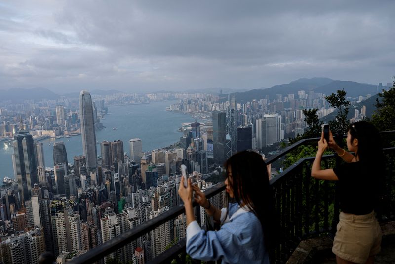 &copy; Reuters. FILE PHOTO: Tourists take photos in front of the financial Central district and Victoria Harbour in Hong Kong, China, May 9, 2023. REUTERS/Tyrone Siu/File Photo