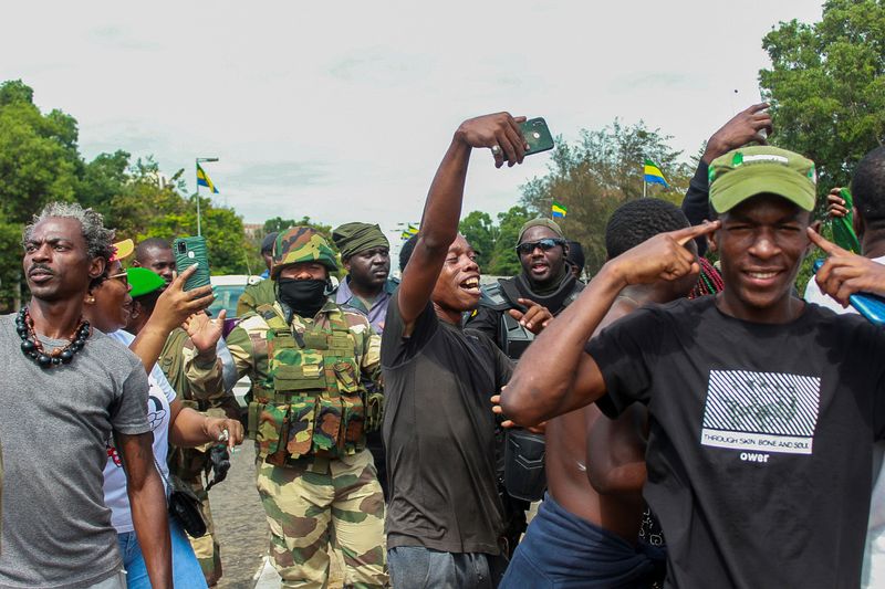 &copy; Reuters. Des gens à Libreville, au Gabon, posent avec des soldats pour célébrer le coup d'État militaire. /Photo prise le 30 août 2023/REUTERS/Scott Ngokila