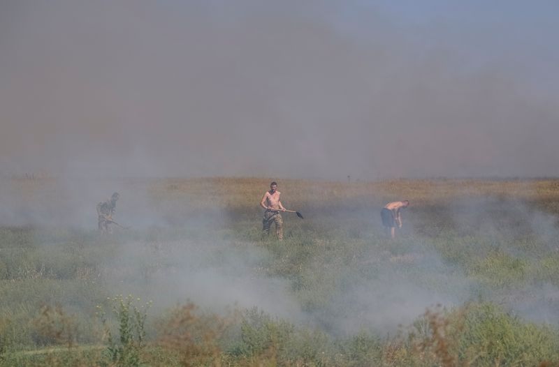 &copy; Reuters. جنود أوكرانيون يقومون بإخماد حريق نشب بالقرب من مواقعهم مع استمرار الهجوم الروسي على أوكرانيا في منطقة زابوريجيا يوم الخميس. تصوير: أولكسند