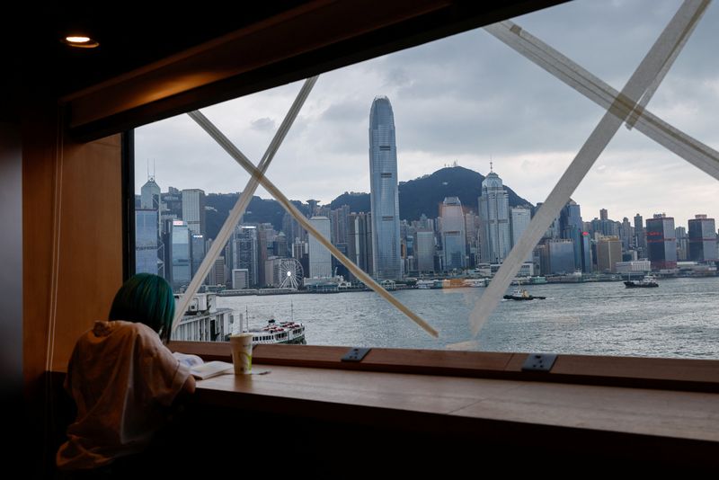 &copy; Reuters. Una muchacha lee un libro en una librería donde las ventanas fueron aseguradas ante la llegada del tifón Saola. Agosto 31, 2023. REUTERS/Tyrone Siu