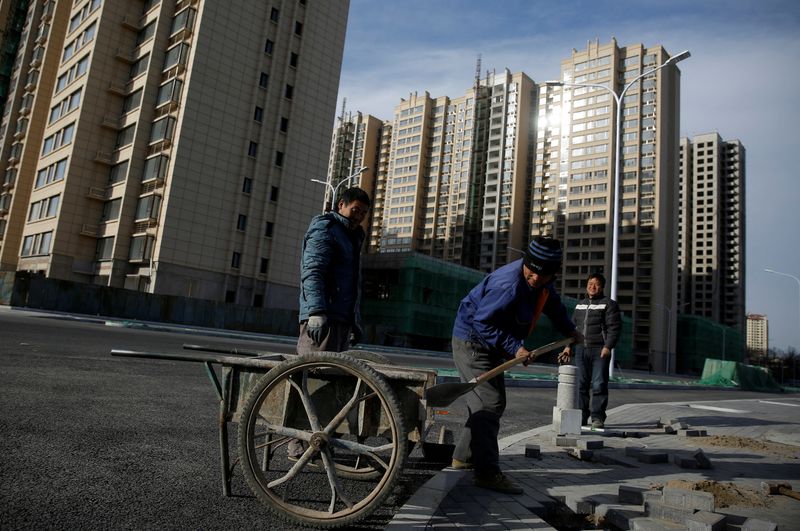 &copy; Reuters. FILE PHOTO: Men work near residential apartment blocks under construction on the outskirts of Beijing, China November 29, 2017. REUTERS/Thomas Peter/File Photo