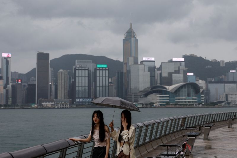 &copy; Reuters. Chinese tourists walk by the seaside as Super Typhoon Saola approaches, in Hong Kong, China September 1, 2023. REUTERS/Tyrone Siu