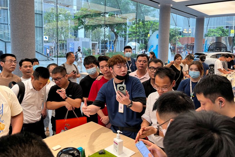 &copy; Reuters. FILE PHOTO: A staff member introduces the new Huawei Mate 60 smartphone to customers at the Huawei flagship store in Shenzhen, Guangdong province, China August 30, 2023. REUTERS/David Kirton/File Photo