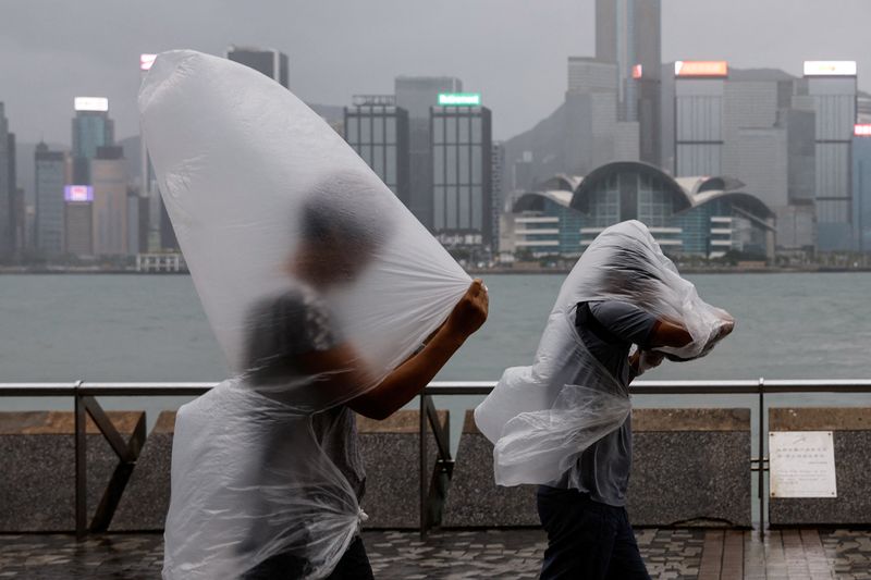 © Reuters. People brave strong winds as Super Typhoon Saola approaches, in Hong Kong, China September 1, 2023. REUTERS/Tyrone Siu