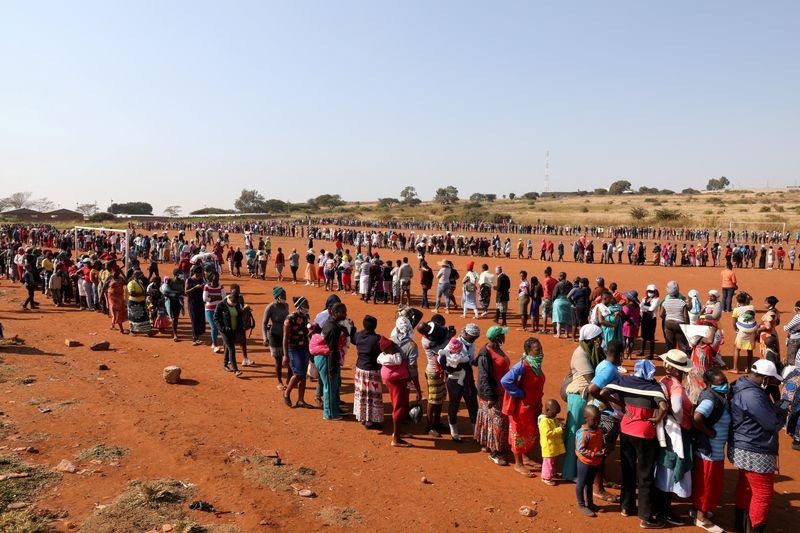 &copy; Reuters. FILE PHOTO: People stand in a queue to receive food aid, during the coronavirus disease (COVID-19) outbreak at the Itireleng informal settlement, near Laudium suburb in Pretoria, South Africa, May 20, 2020. REUTERS/Siphiwe Sibeko/File Photo