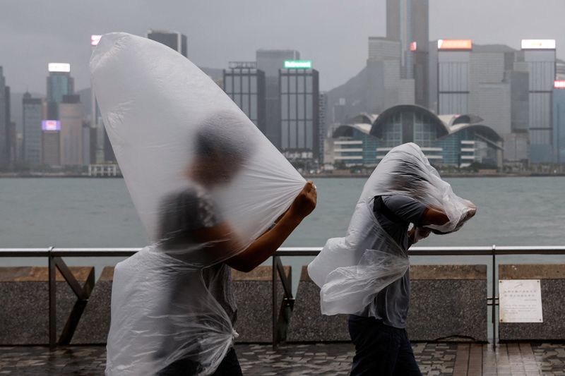&copy; Reuters. Pessoas se protegem em Hong Kong
 1/9/2023   REUTERS/Tyrone Siu
