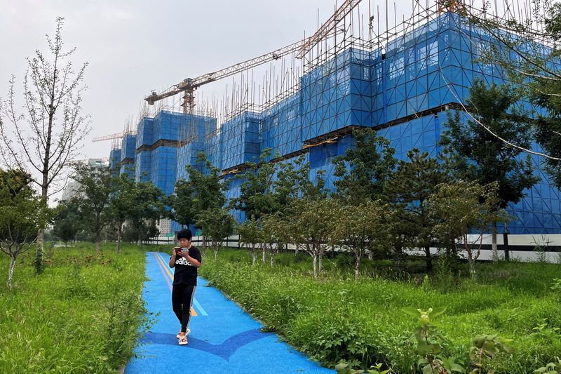 &copy; Reuters. FILE PHOTO: A person walks past a construction site of residential buildings by Chinese developer Country Garden, in Beijing, China August 11, 2023. REUTERS/Tingshu Wang/File Photo
