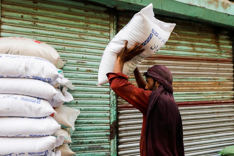 &copy; Reuters. A labourer stacks sacks of sugar outside a shop at a wholesale market in Karachi, Pakistan June 9, 2023. REUTERS/Akhtar Soomro/File photo