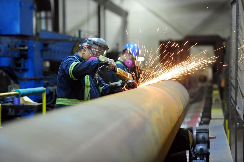 © Reuters. FILE PHOTO: Workers are seen at Bri-Steel Manufacturing, a manufacturer and distributer of large diameter seamless steel pipes, in Edmonton, Alberta, Canada June 21, 2018. REUTERS/Candace Elliott/File Photo