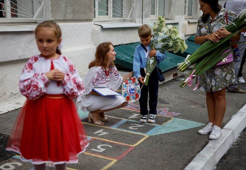 &copy; Reuters. A first grader reacts as his teacher speaks with him during a ceremony to mark the start of the new school year, amid Russia's attack on Ukraine, in Kyiv, Ukraine September 1, 2023. REUTERS/Gleb Garanich    