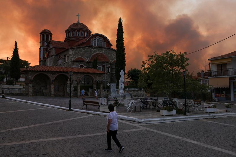 &copy; Reuters. A local watches smoke rising behind a church at the village of Dadia, as a wildfire burns at the Dadia National Park on the region of Evros, Greece, September 1, 2023. REUTERS/Alexandros Avramidis