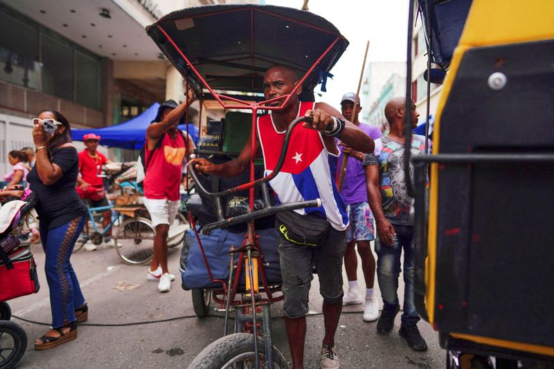 &copy; Reuters. FILE PHOTO: A man pushes a tricycle loaded with goods at a street market in Havana, Cuba, August 19, 2023. REUTERS/Alexandre Meneghini/File Photo
