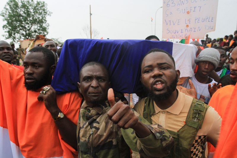 © Reuters. Demonstrators carry a coffin covered with a French flag while thousands of Nigeriens gather in front of the French army headquarter, in support of the putschist soldiers and to demand the French army to leave, in Niamey, Niger September 2, 2023. REUTERS/Mahamadou Hamidou 