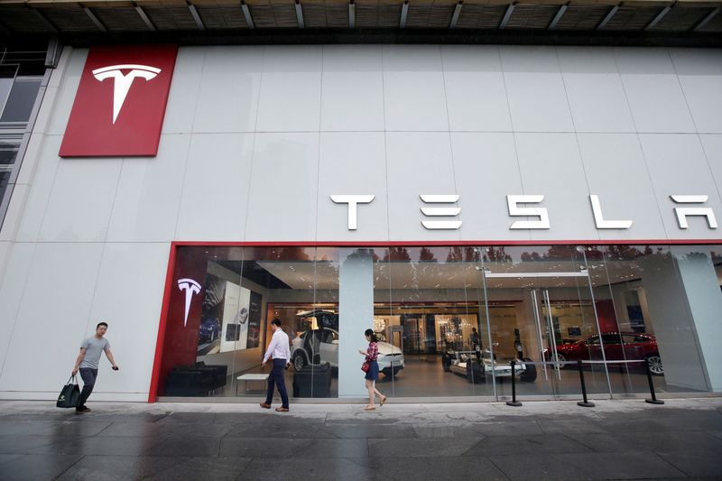 &copy; Reuters. FILE PHOTO: FILE PHOTO: People walk past a showroom outside Tesla China headquarters at China Central Mall in Beijing, China July 11, 2018. REUTERS/Jason Lee/File Photo