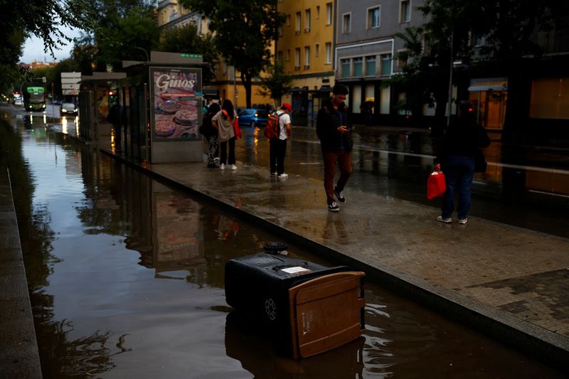 &copy; Reuters. People wait for the bus by a flooded road caused by heavy rain, following a red alert for a severe storm from Spain's State Meteorological Agency (AEMET), in Madrid, Spain, September 4, 2023. REUTERS/Susana Vera