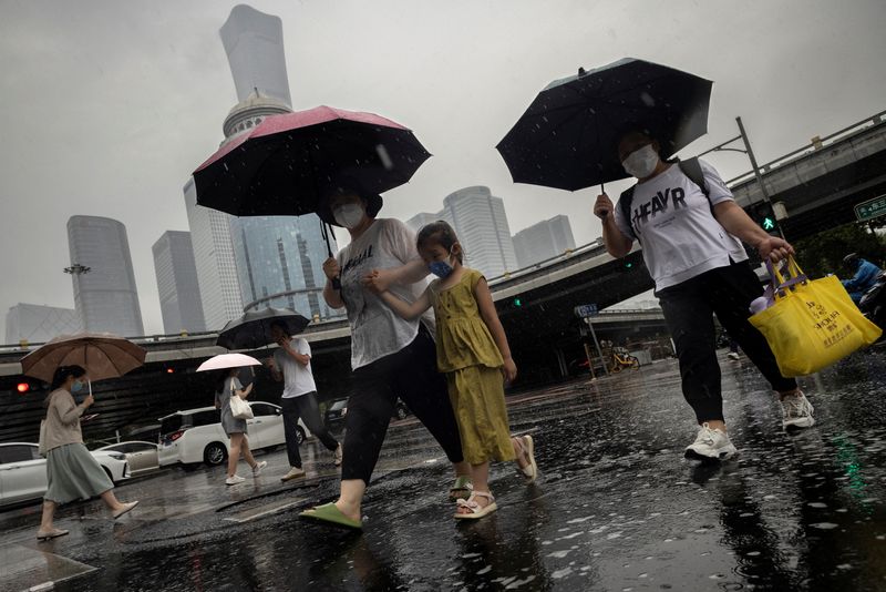 &copy; Reuters. FOTO DE ARCHIVO: La gente camina en el Distrito Central de Negocios en un día lluvioso, en Beijing, China, 12 de julio de 2023. REUTERS/Thomas Peter/Foto de archivo 