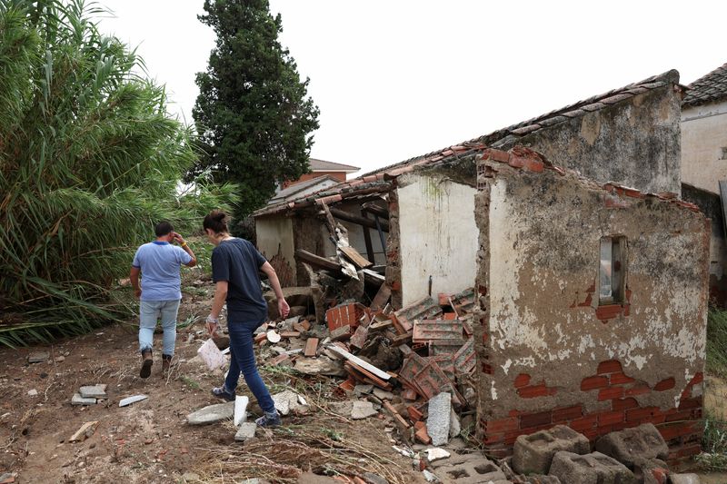 &copy; Reuters. شخصان يتفقدان منزلا مدمرا بفعل الفيضانات التي اجتاحت منطقة كامارينا في إقليم طليطلة بوسط إسبانيا يوم الاثنين . تصوير : إيزابيل إنفانتيس- روي