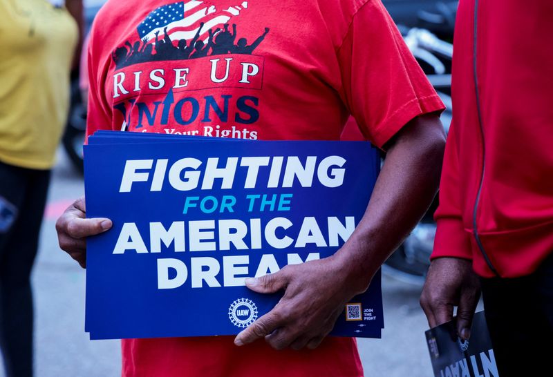 © Reuters. A United Auto Workers union member holds a sign outside Stellantis Sterling Heights Assembly Plant, to mark the beginning of contract negotiations in Sterling Heights, Michigan, U.S.  July 12, 2023.  REUTERS/Rebecca Cook/File Photo