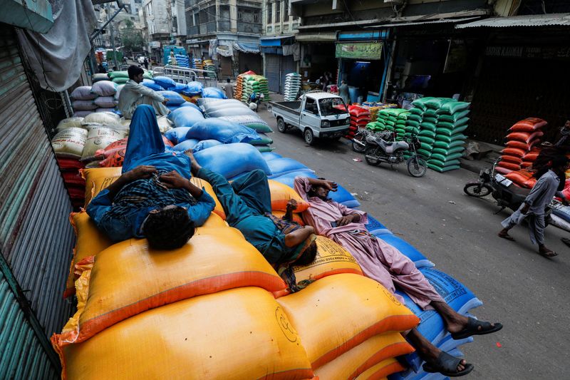 &copy; Reuters. Labourers take nap on the sacks of grains and sugar, after offloading from a supply truck, outside shops at the wholesale grain market in Karachi, Pakistan July 20, 2023. REUTERS/Akhtar Soomro/File Photo