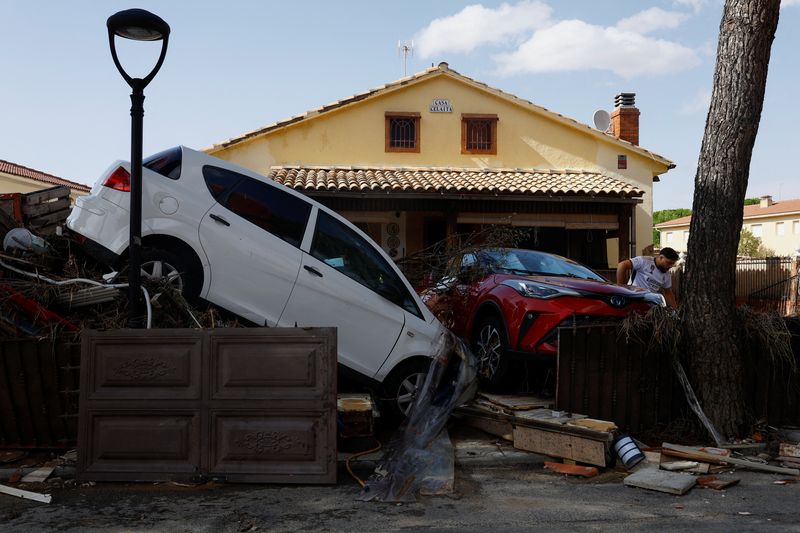 © Reuters. السيارات متكدسة خارج منزل بعد  حدوث فيضانات في إسبانيا يوم الخميس. تصوير: سوزانا فيرا- رويترز.